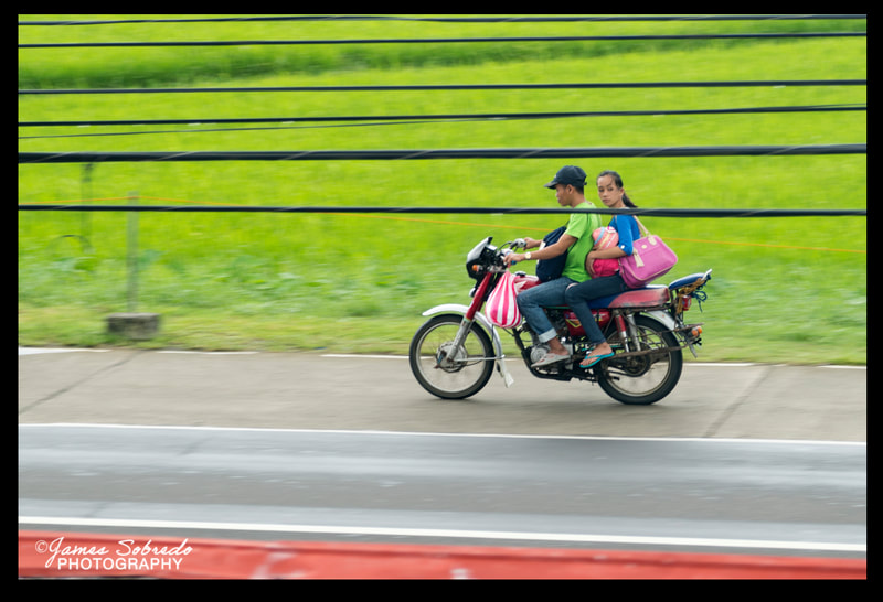Woman riding "Angkas" (pillion) on Motorcycle, Aklan, Philippines